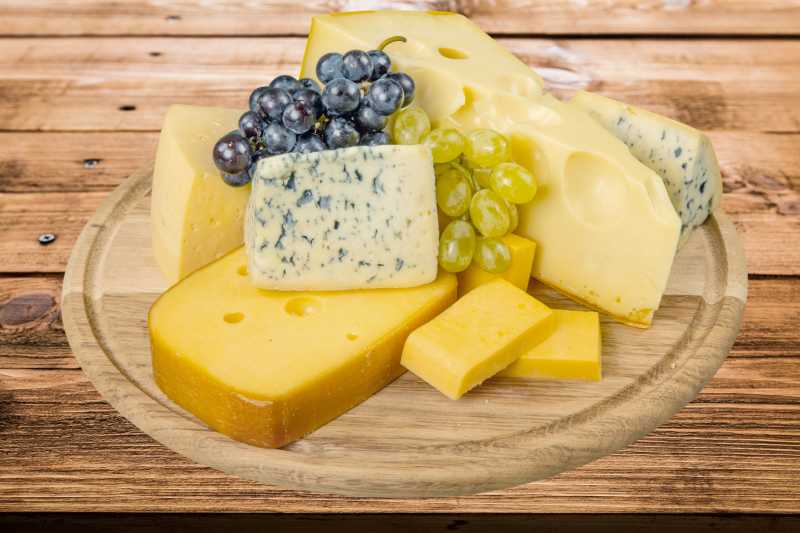 木盘中奶酪葡萄等食物