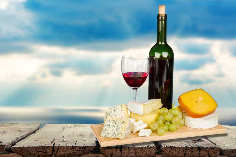 天空背景下奶酪及红酒特写
