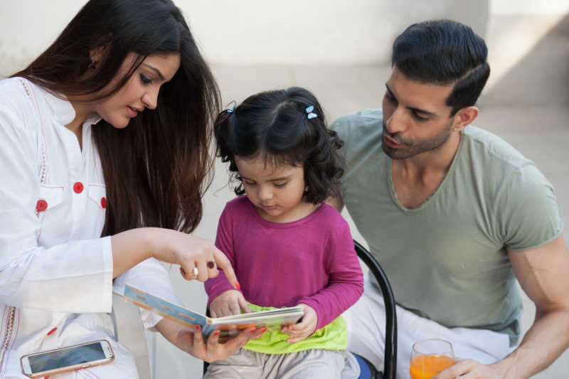 快乐的一家三口看着画册