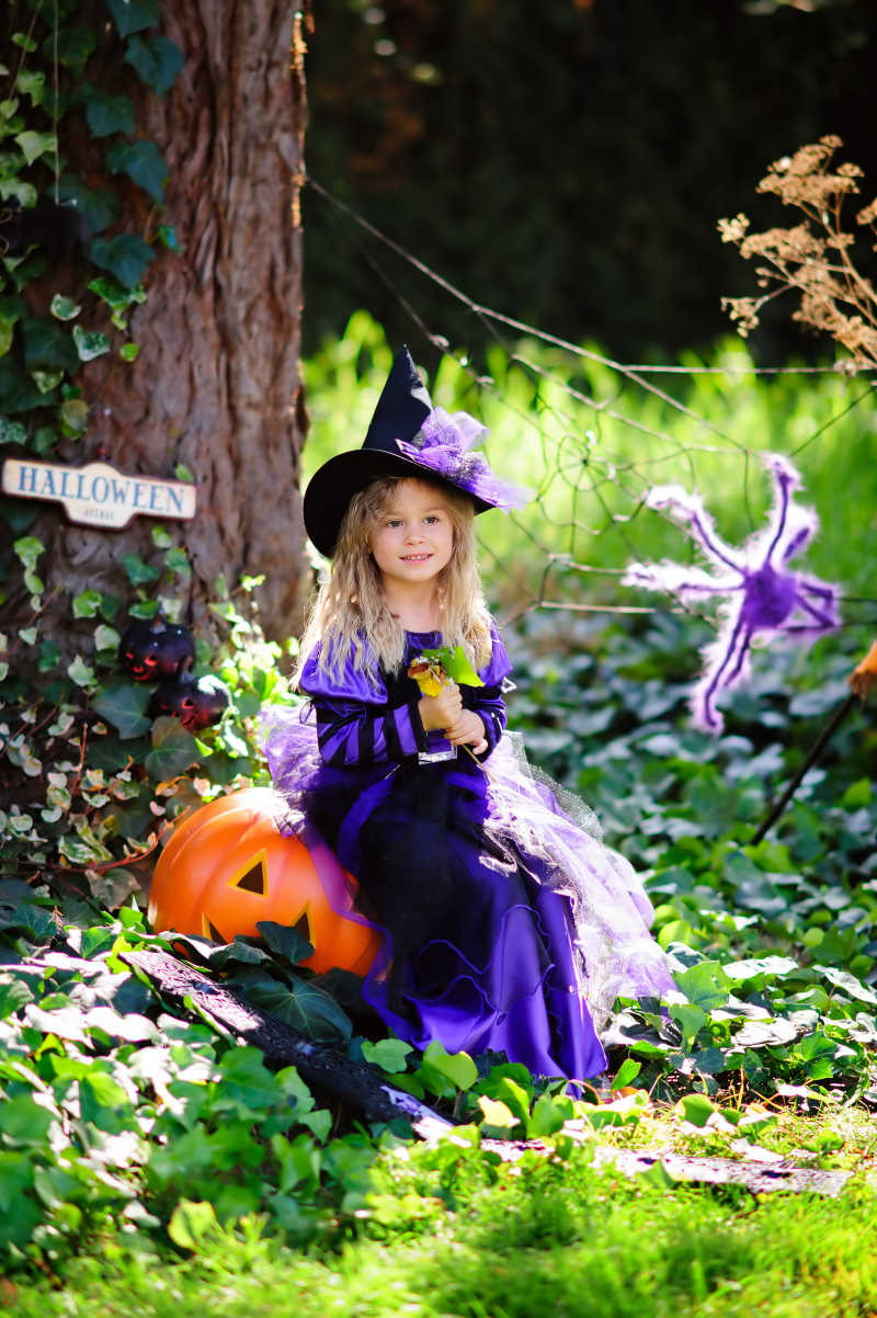 圣诞节坐在大南瓜灯上的小女孩