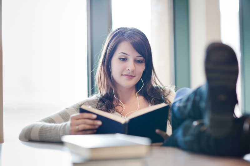 大学生听着音乐看着书