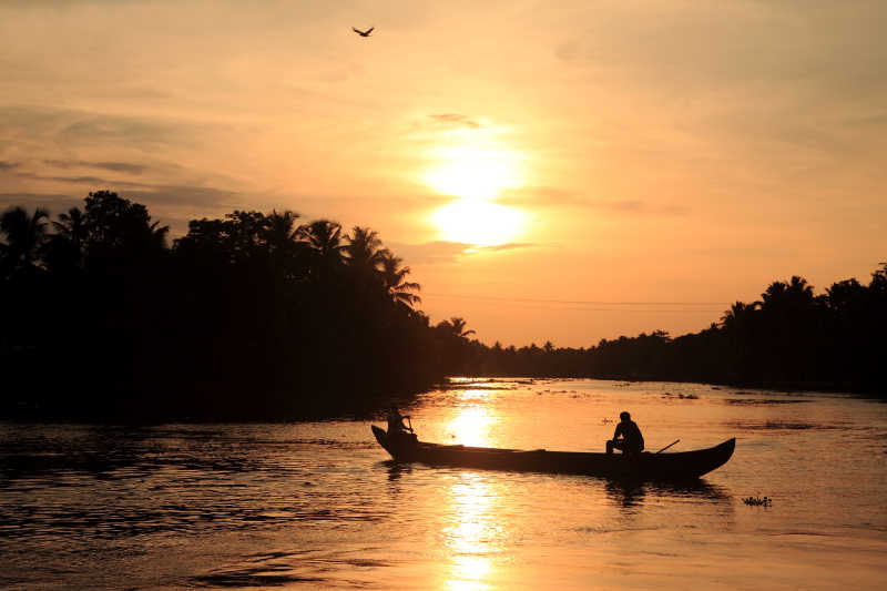 印度日落晚霞下湖面上的船只
