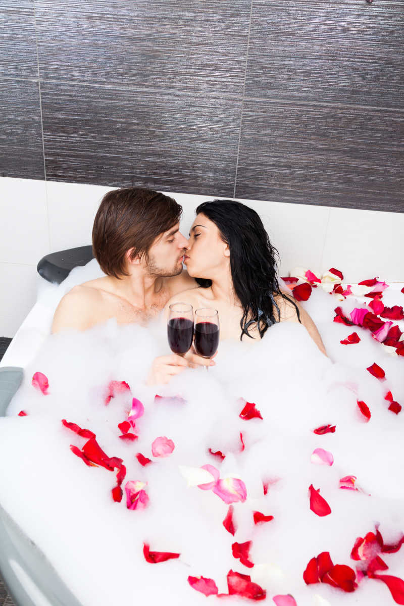 Пара в ванной с лепестками роз