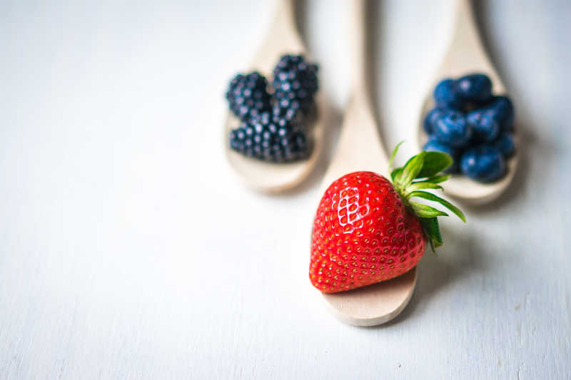 木制背景下新鲜草莓和浆果特写
