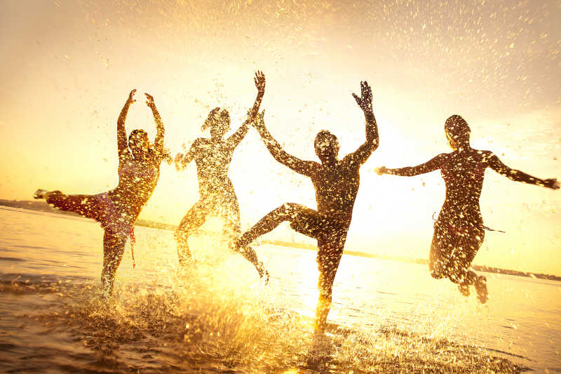 一群快乐的年轻人在沙滩上跳舞