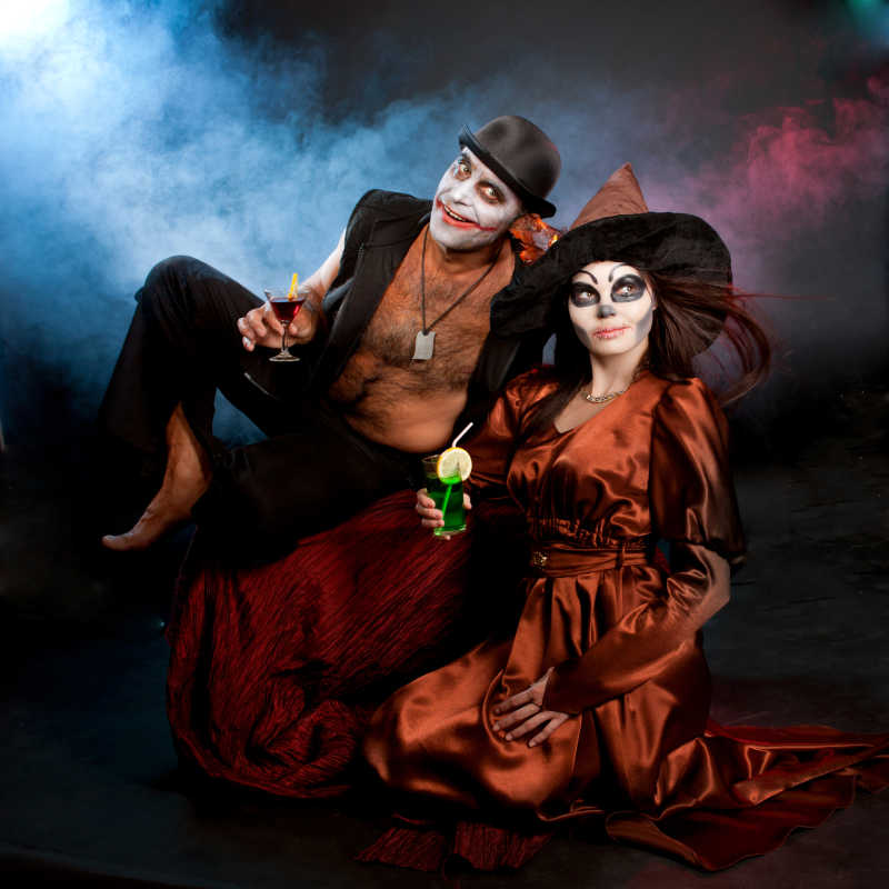 在万圣节的晚上男人和女人穿成小丑和巫婆