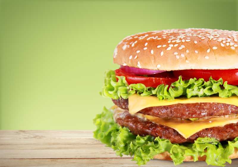 绿色背景中的牛肉番茄汉堡