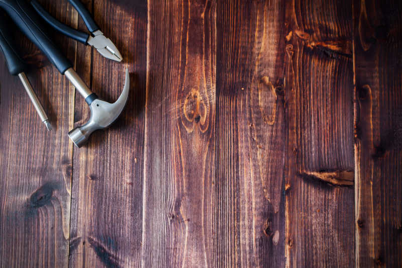 锤子钳子螺丝刀在老年暗木乡村背景的工具