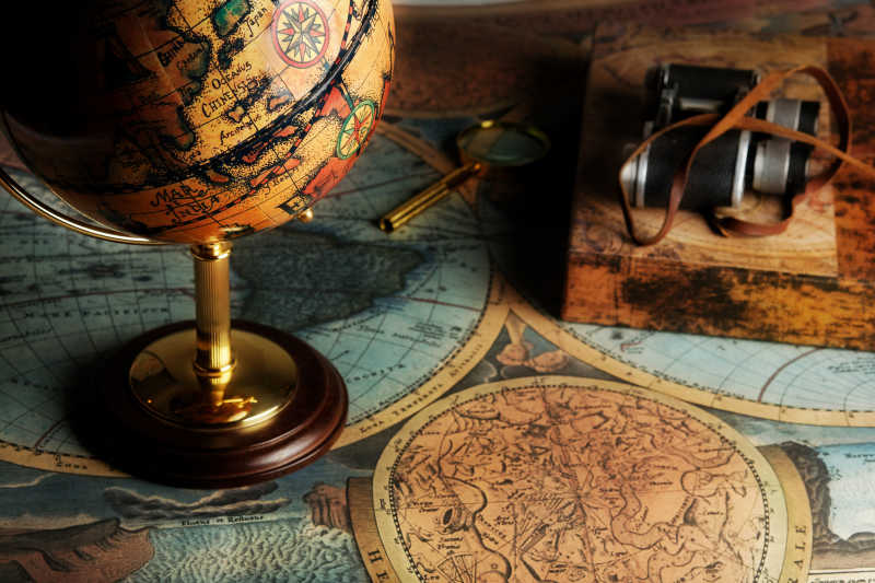 老式地图上的老式地球仪和照相机