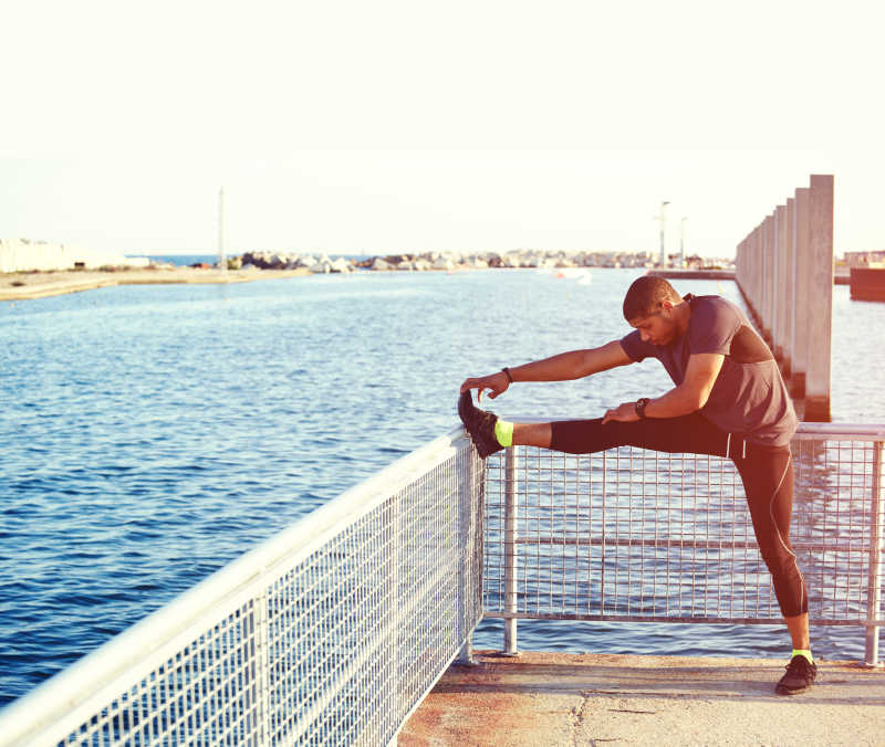 海面上做腿部伸展运动的男人