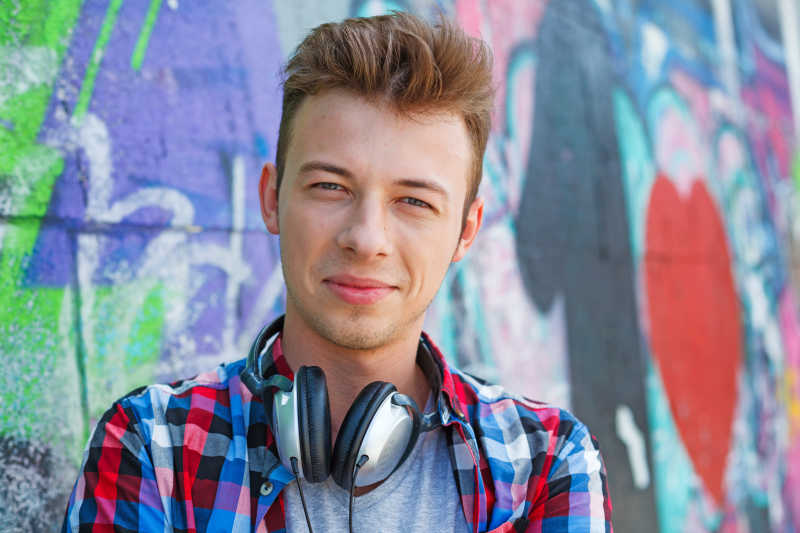 靠在涂鸦墙面上的年轻人