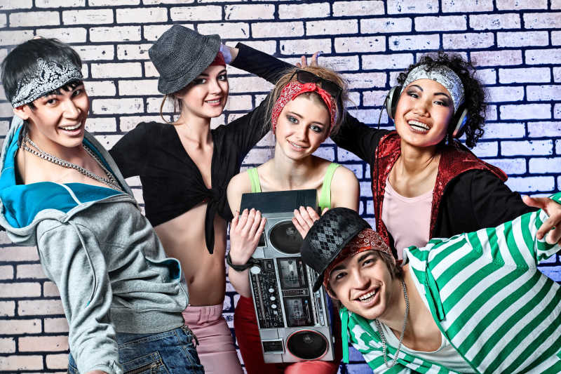 砖墙前面的五个时髦青年