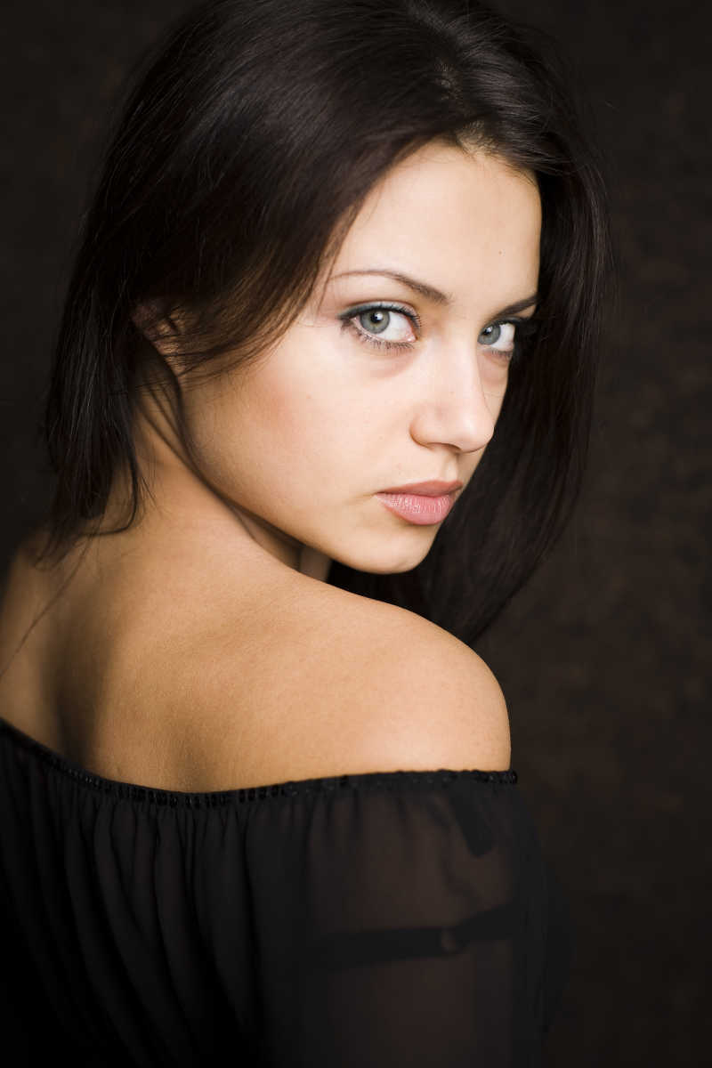 黑色背景中黑发女青年写真