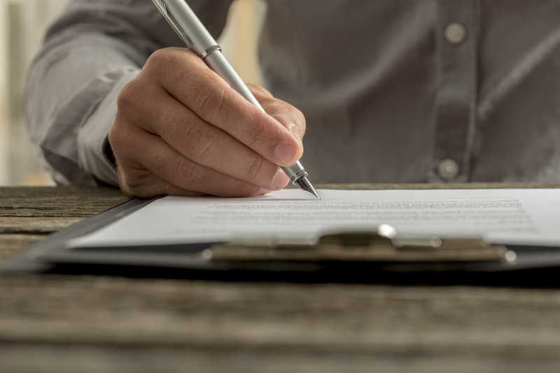 男性的手签商业合同或文件特写