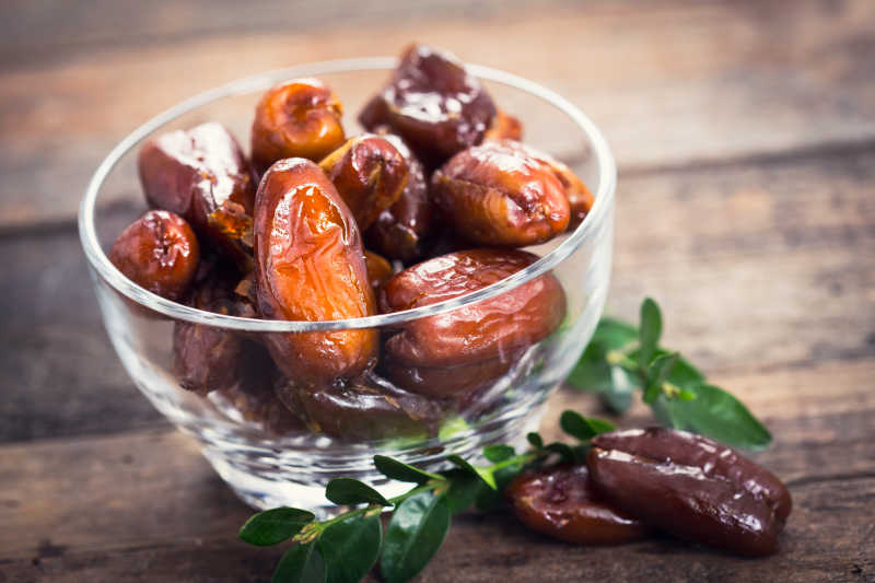 木质桌面上玻璃碗中的蜜枣