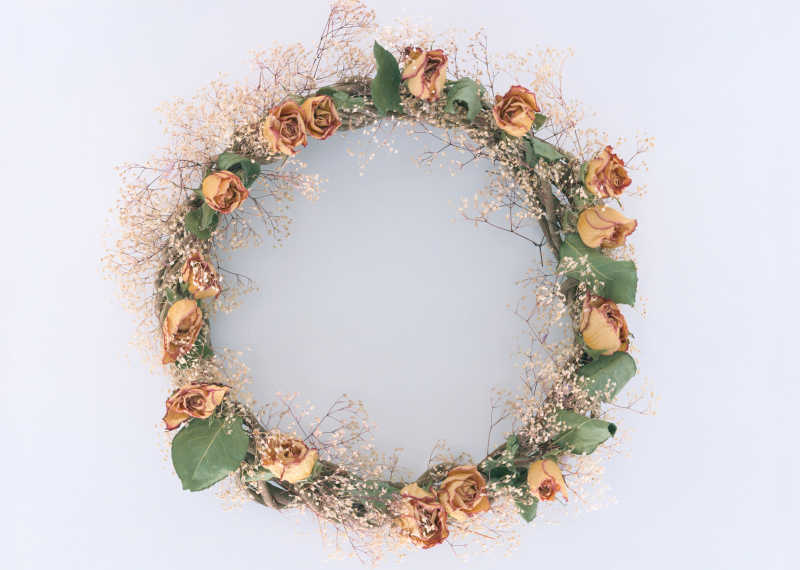 白色背景下黄色花朵编制的花环