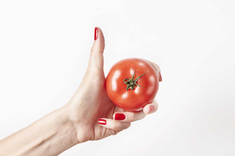 女士手里拿着新鲜的西红柿