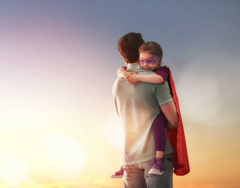 父亲抱着女儿在看日落