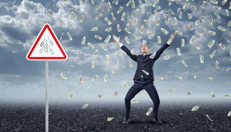 写着钱的交通警示牌和男人在许多钱底下兴奋的大叫