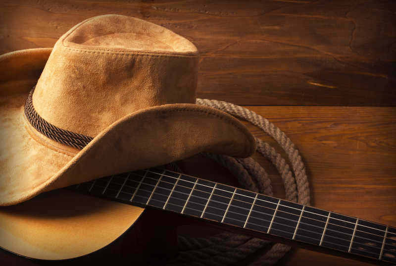 木质桌板上的吉他绳子和爵士帽