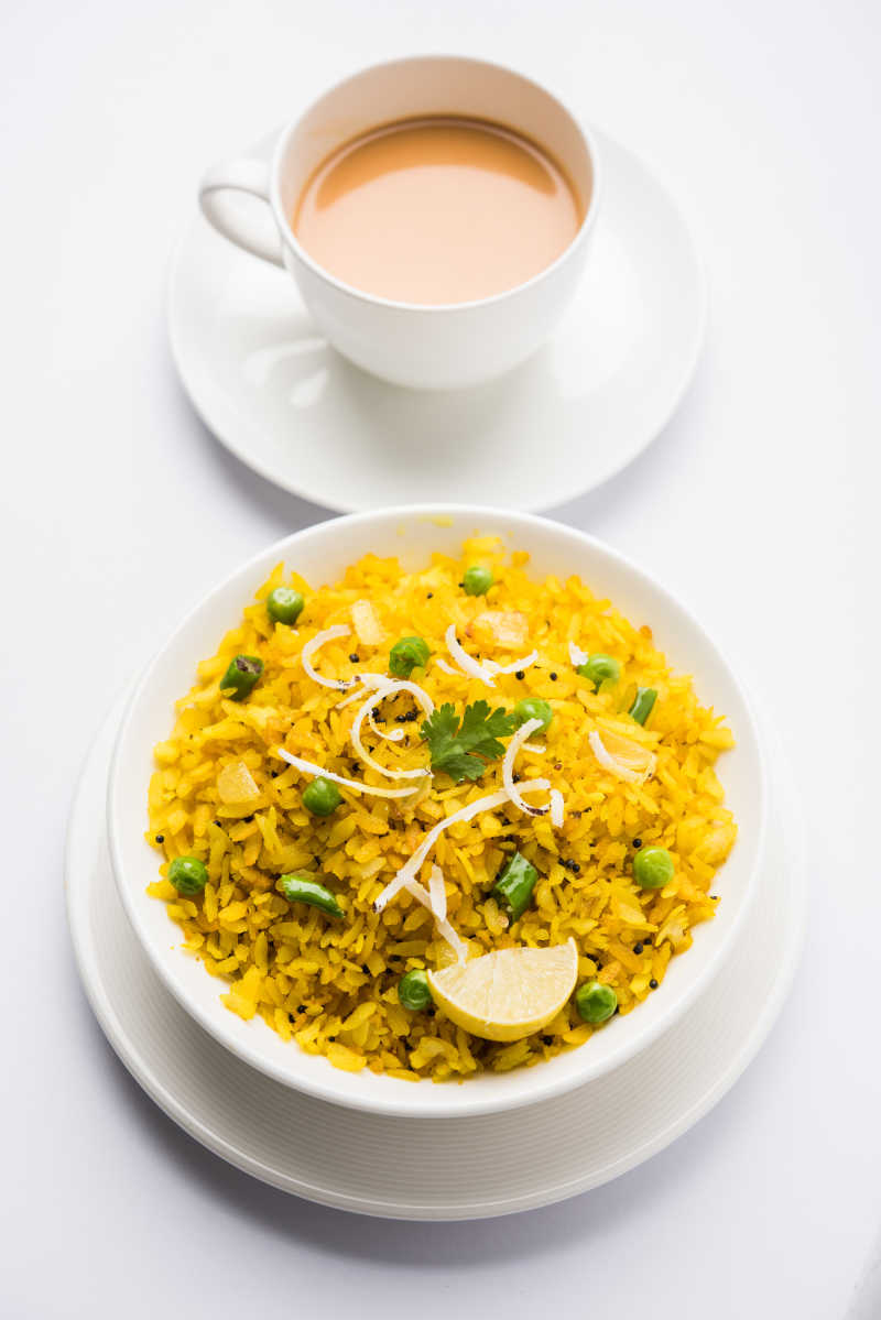 白色桌子上的黄色蛋炒饭和咖啡