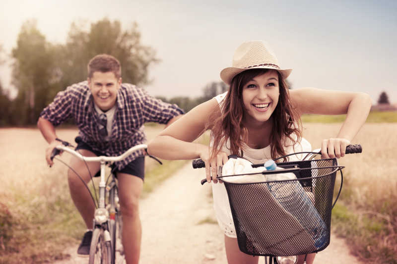 相间道路上骑自行车快乐的情侣