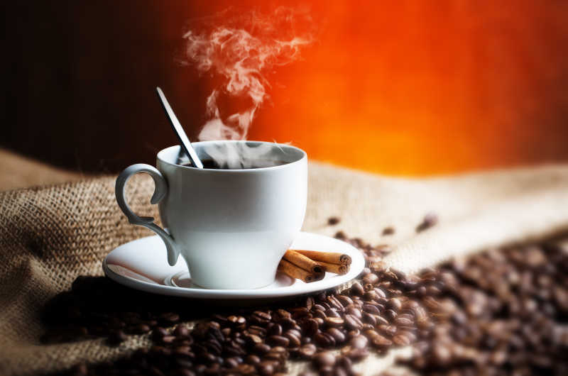 白色咖啡杯里的热咖啡和咖啡豆