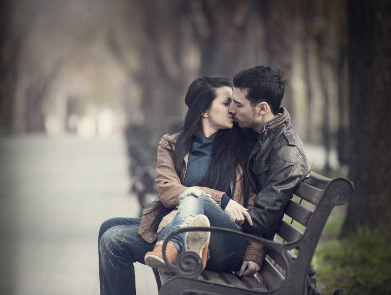 夫妇在小巷的长凳上接吻