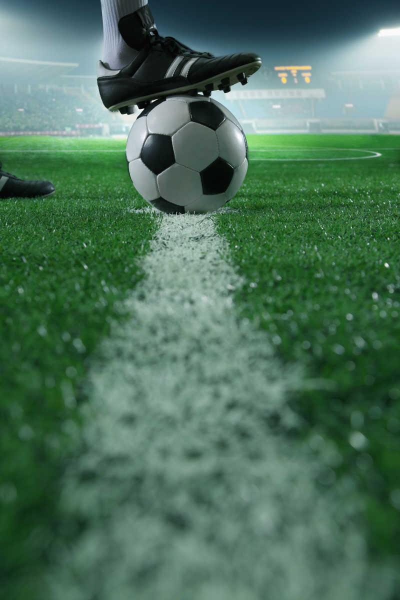 在足球线上把脚顶在足球上特写
