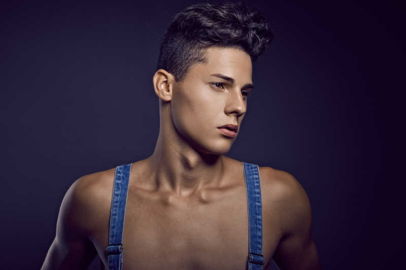 蓝色背景下英俊男子身穿牛仔时尚写真