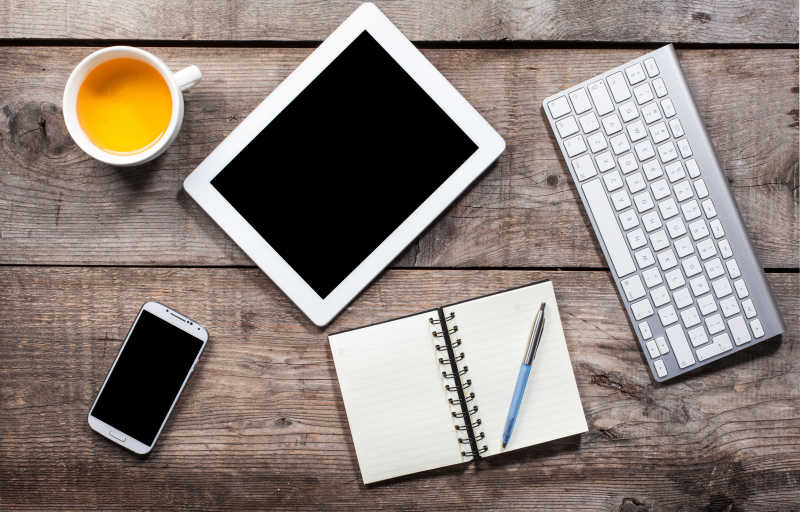 木桌上的办公用品和电子科技还有茶