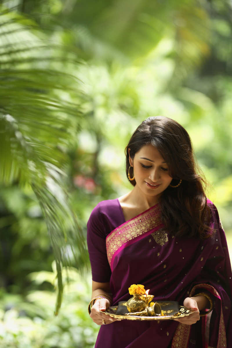 紫衣印度美女端着盘子里面放着油灯和花
