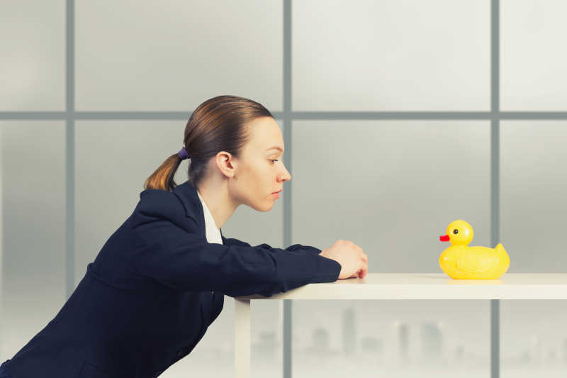 年轻的商人与桌上的黄色橡皮鸭