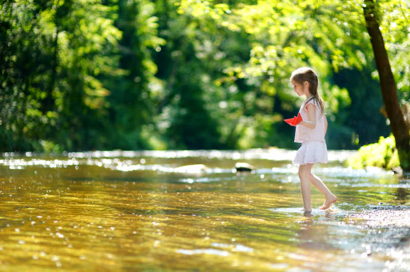 夏日阳光明媚的河流里的小女孩