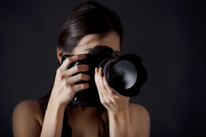 黑色背景上女摄影师