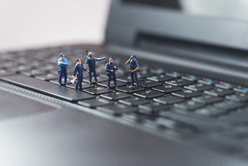 黑色电脑键盘上的微型警察