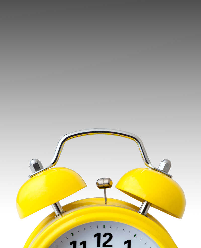 灰色背景下的黄色闹钟