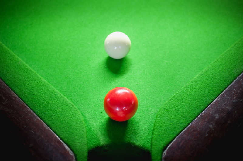 台球桌上放着红白两色的台球