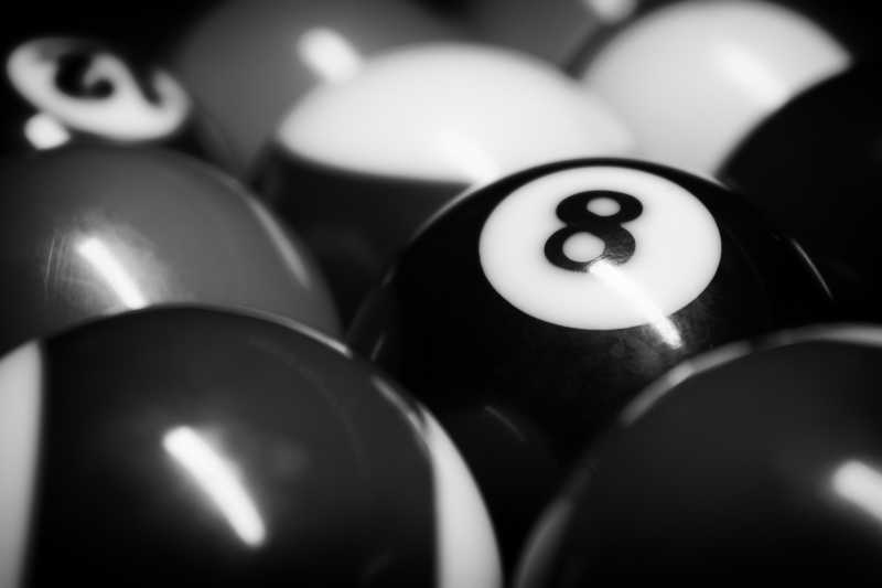 一堆台球中放着一个黑色的8号台球