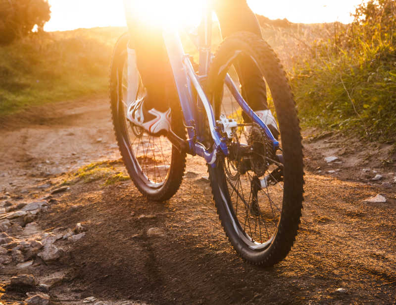 日落时在泥土上骑自行车特写