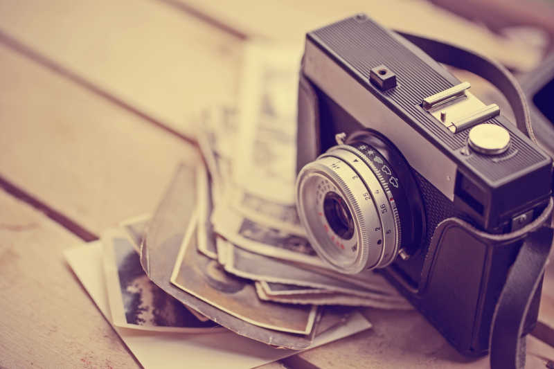 木板上的老式相机和旧照片