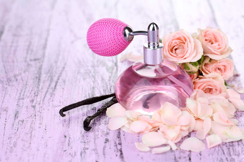 桌上摆放的一瓶香水和玫瑰花瓣