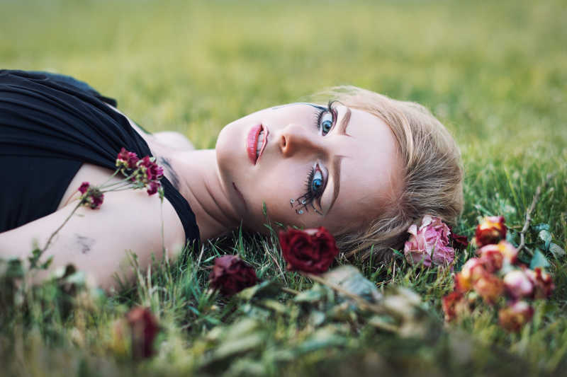 带着鲜花的含泪女孩的时尚肖像