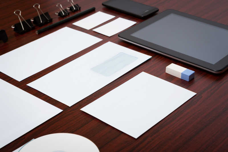 棕色木桌上的空白纸片和办公模板