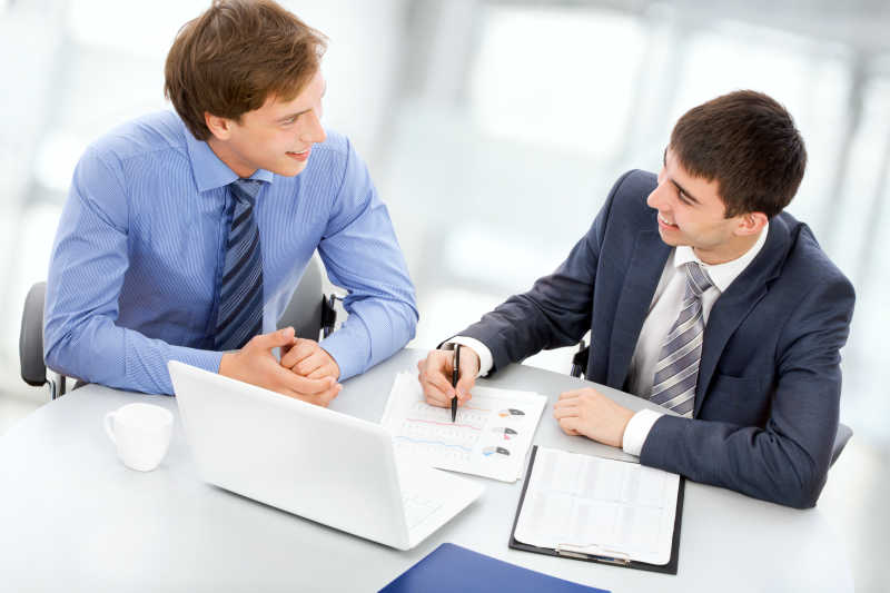 两个在笔记本电脑上工作的商人