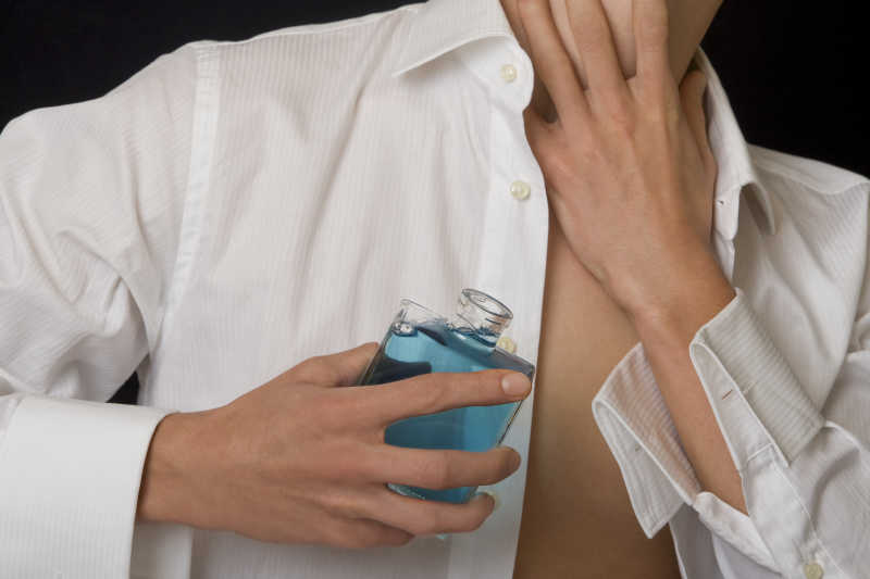 手拿蓝色香水瓶的男人