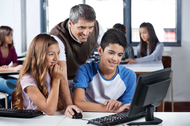 男老师和学生使用台式电脑