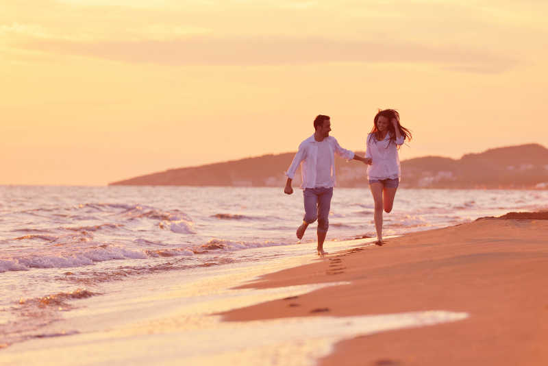 浪漫的情侣在海滩上慢跑