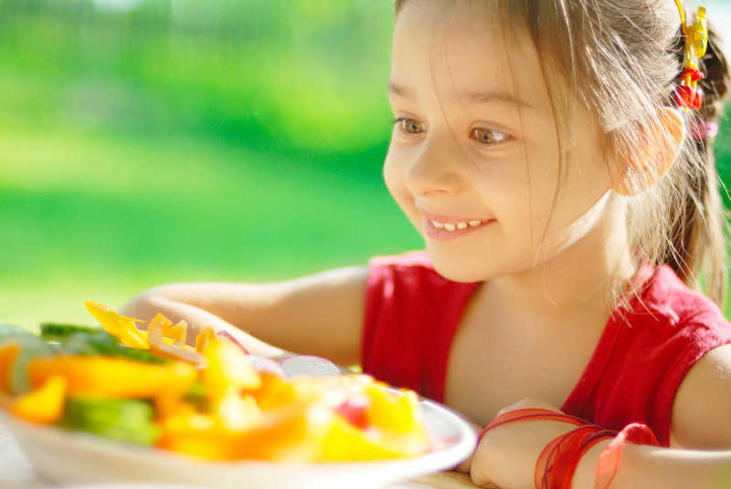看着一盘菜高兴的小女孩