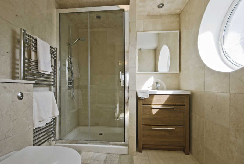 简约装修浴室里的玻璃围挡淋浴间和洗手盆马桶等设备